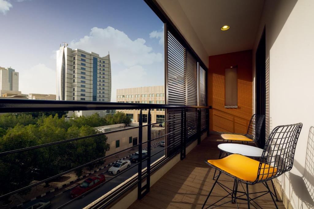A private balcony with orange chairs overlooking the Dammam skyline